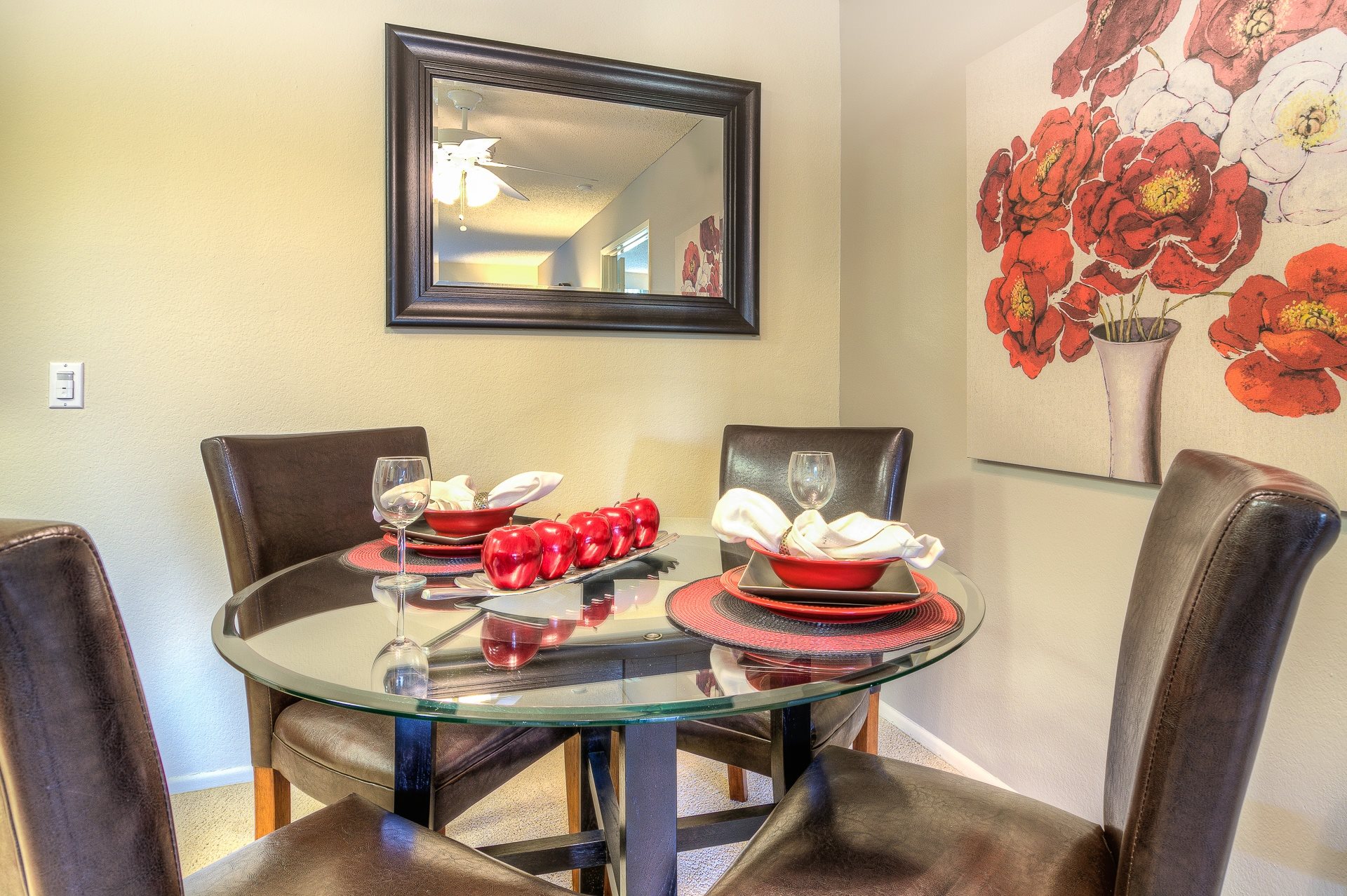 A dining table with chairs and a painting on the wall.,A dining table with chairs and a painting on the wall.